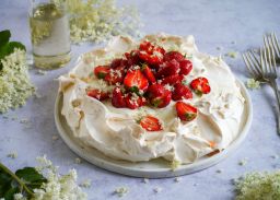 Pavlova mit Holunderblüten und Erdbeeren