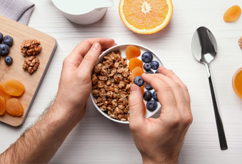 Ein Mann isst Beerenmüsli