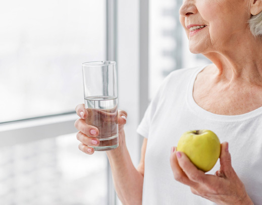 Frau mit Wasserglas und Apfel