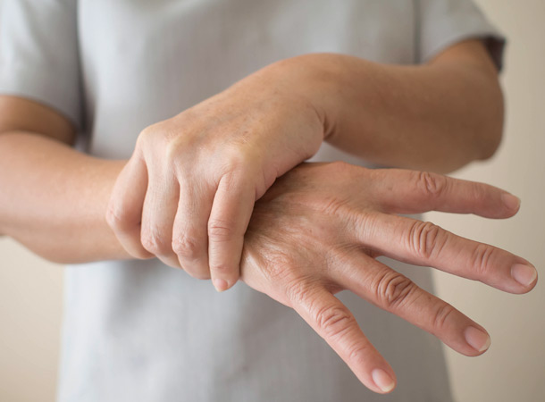 Frau hält sich die Hand