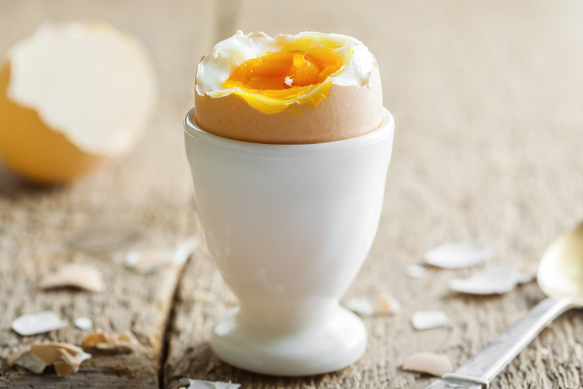 Ein offenes Frühstücksei steht im Eierbecher bereit zum Genuss.