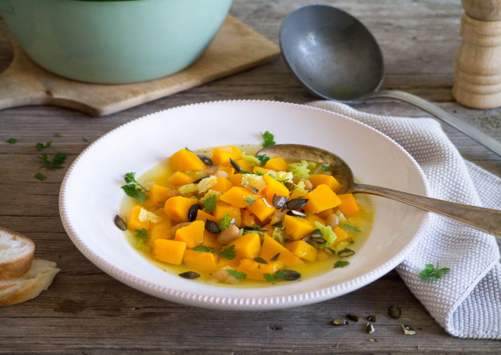 Teller mit Suppe und Kürbisstückchen