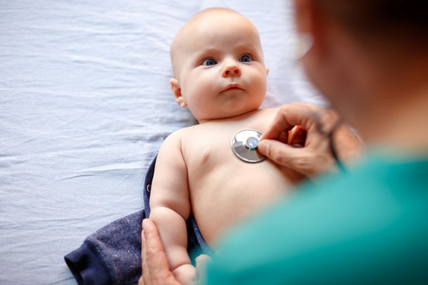A baby is being monitored with the stethoscope.