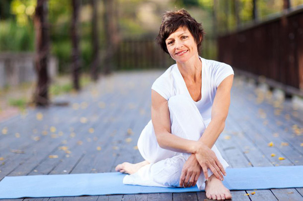 Bewegung in der Natur hilft besser mit Stress umzugehen. Eine Frau entspannt nach dem Sport im Freien auf ihrer Gymnastikmatte. (Foto: 123RF, Hongqi Zhang)