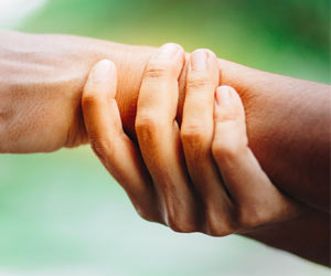 Man sieht die Hände einer Person auf dem Bild. Die einte Hand hält das Handgelenk der anderen entlastend fest. 