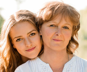 Eine junge Frau umarmt Ihre Mutter liebevoll. Die Beziehung einer Mutter zu Ihrer Tochter, kann durch den Auszug sogar intensiver werden.