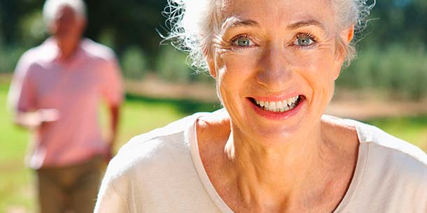 Eine Seniorin joggt bei strahlendem Wetter durch die Natur. Bewegung kann entzündlichen Prozessen entgegenwirken.