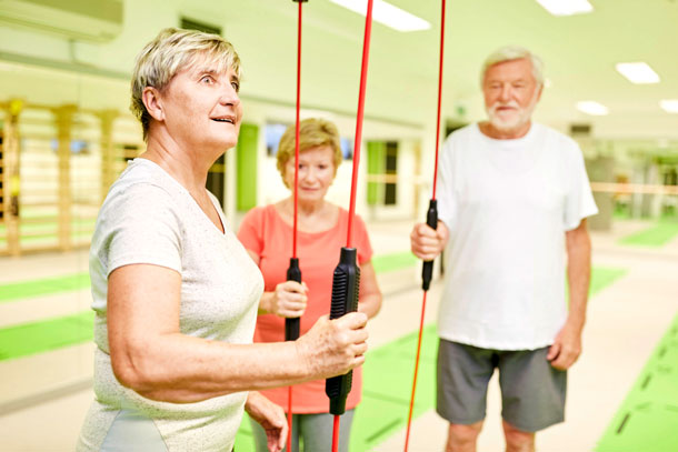 Training mit dem Schwungstab (Foto:123RF, stylephotographs ) Senioren in einer Trainingshalle mit Schwungstäben in den Händen.