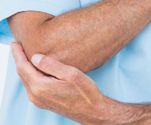 Psoriasis-Arthritis: Schmerzhafter Begleiter der Schuppenflechte (Foto: Mann hält bzw. schützt seinen Ellenbogen mit seiner anderen Hand. 123RF, Wavebreak Media Ltd.)