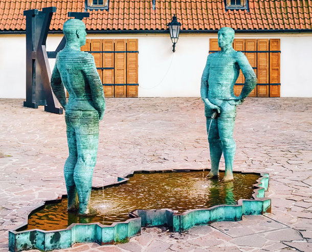 Sinnbild für das Wasserlassen von Männern. Männliche Skulpturen urinieren in einen Brunnen.