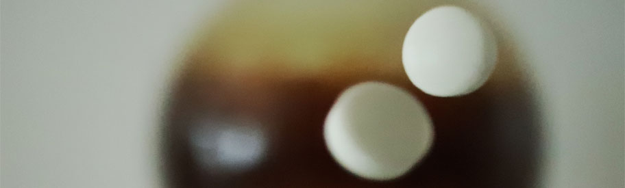 Weisse, runde Tabletten fallen in einem Labor auf den Tisch.
